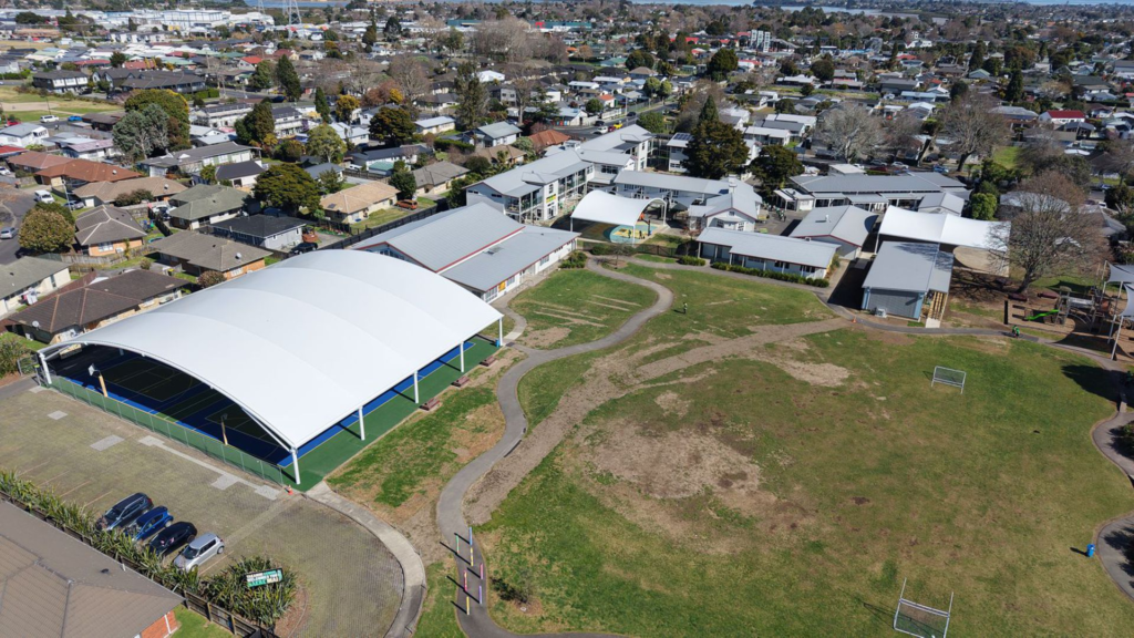 Aerial view of an OPAL tension membrane shade canopy over a New Zealand school court, engineered and built by Spaceframe